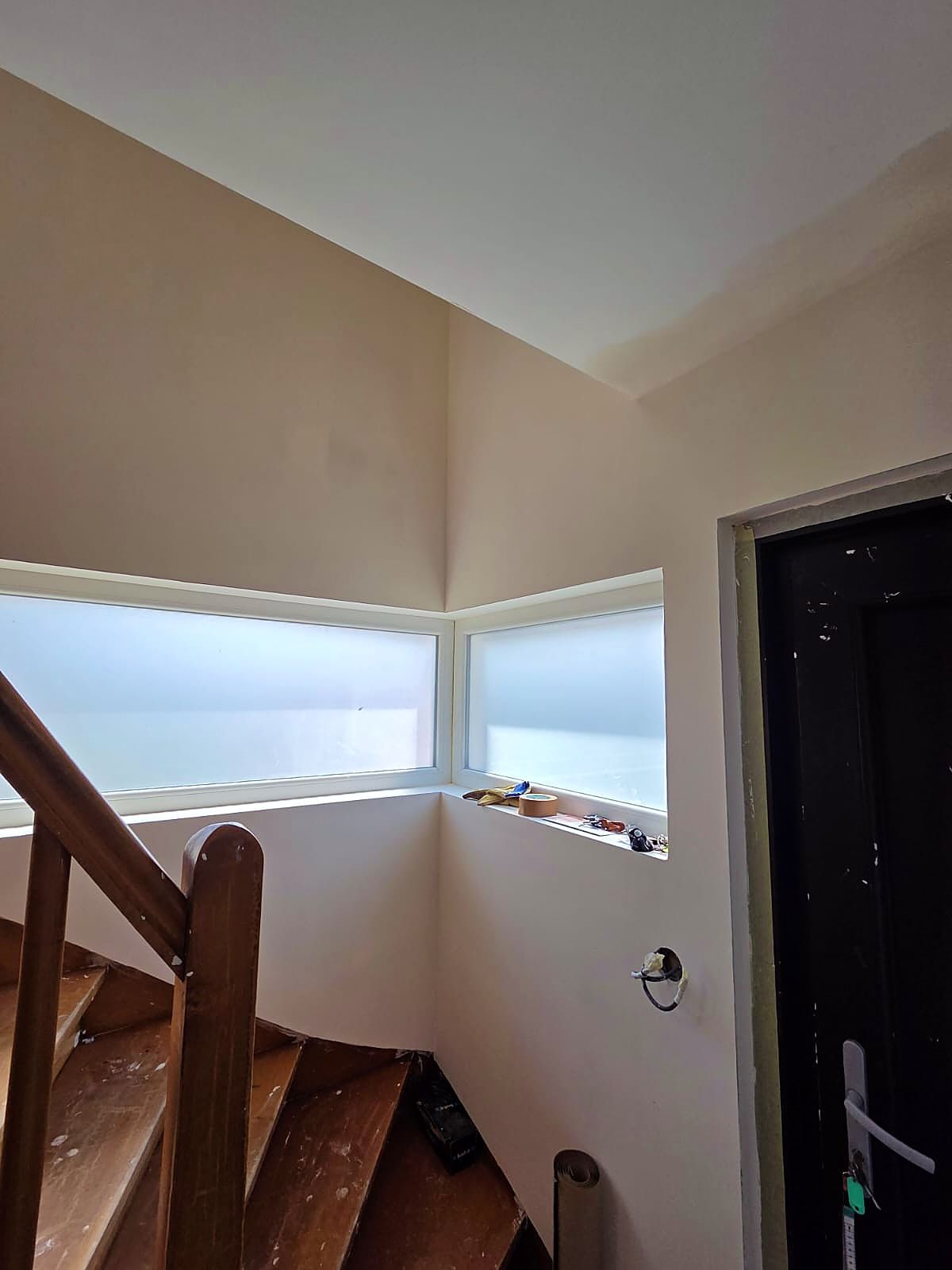 Cage d’escalier à Dunkerque après travaux, murs lisses et peints autour des fenêtres d’angle