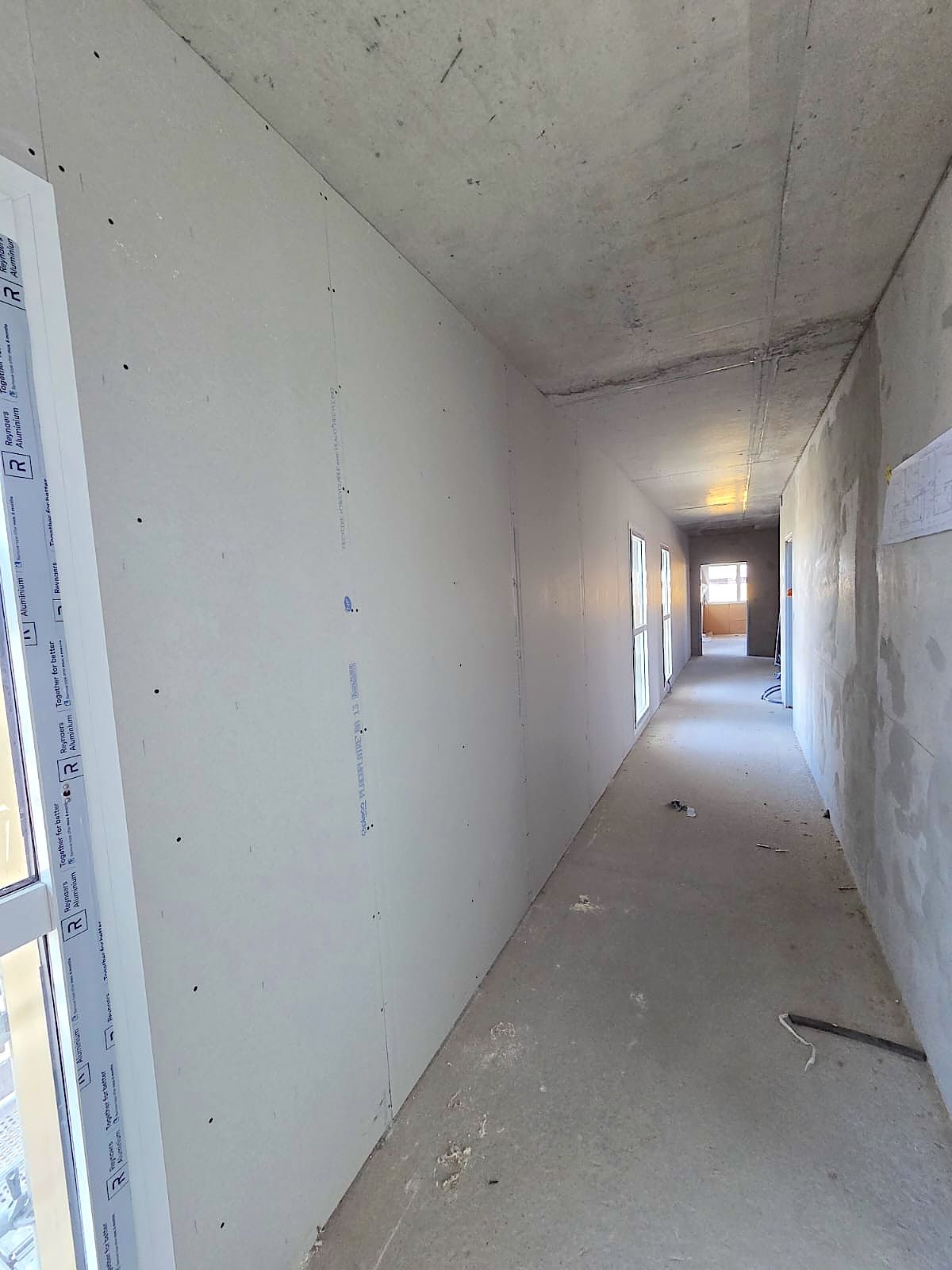 Couloir à Dunkerque après la pose des plaques de plâtre sur toute la longueur du mur