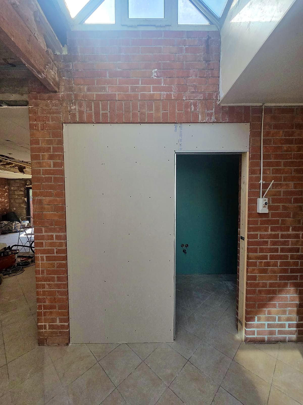 Pièce en briques à Dunkerque, cloison en plaques de plâtre fermée avec son ouverture de porte