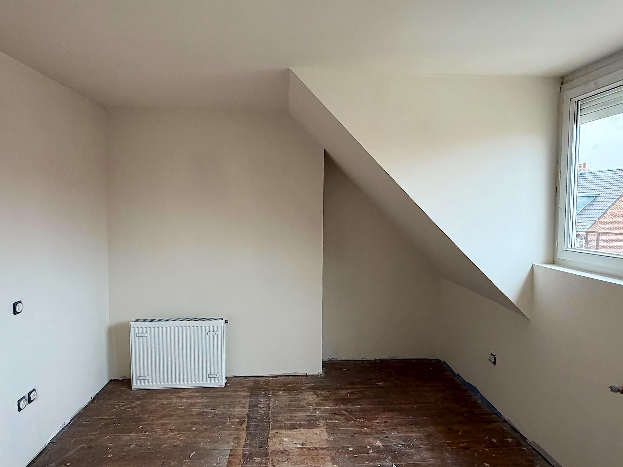 Chambre sous combles à Lille après peinture, rampant et murs blancs avec radiateur posé, prêt à peindre