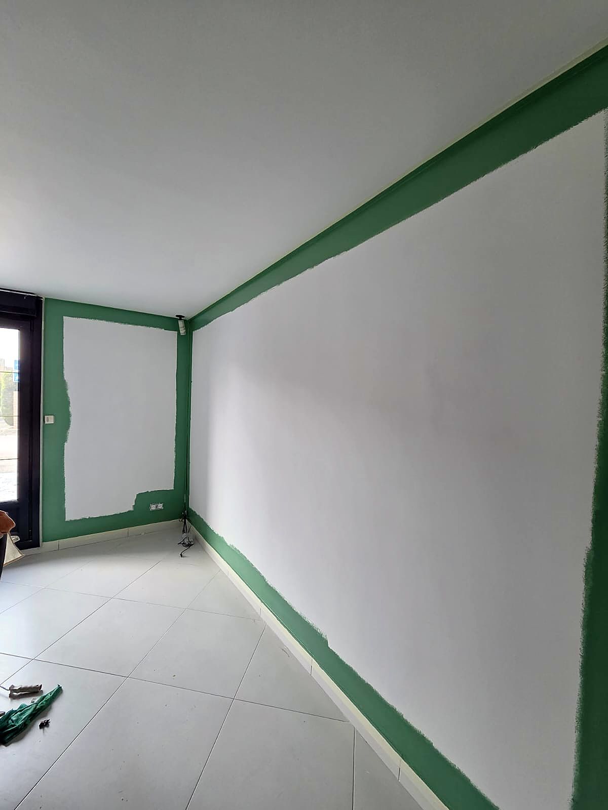Salon à Dunkerque pendant la mise en peinture, réchampis verts en bordure des murs blancs