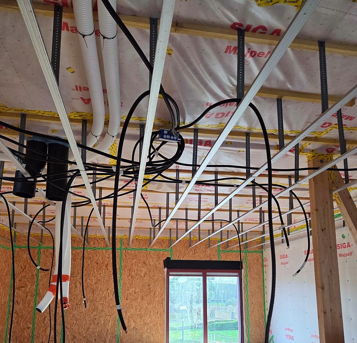 Grande pièce à ossature bois à Dunkerque avant la pose du plafond, fourrures métalliques, pare-vapeur et gaines électriques